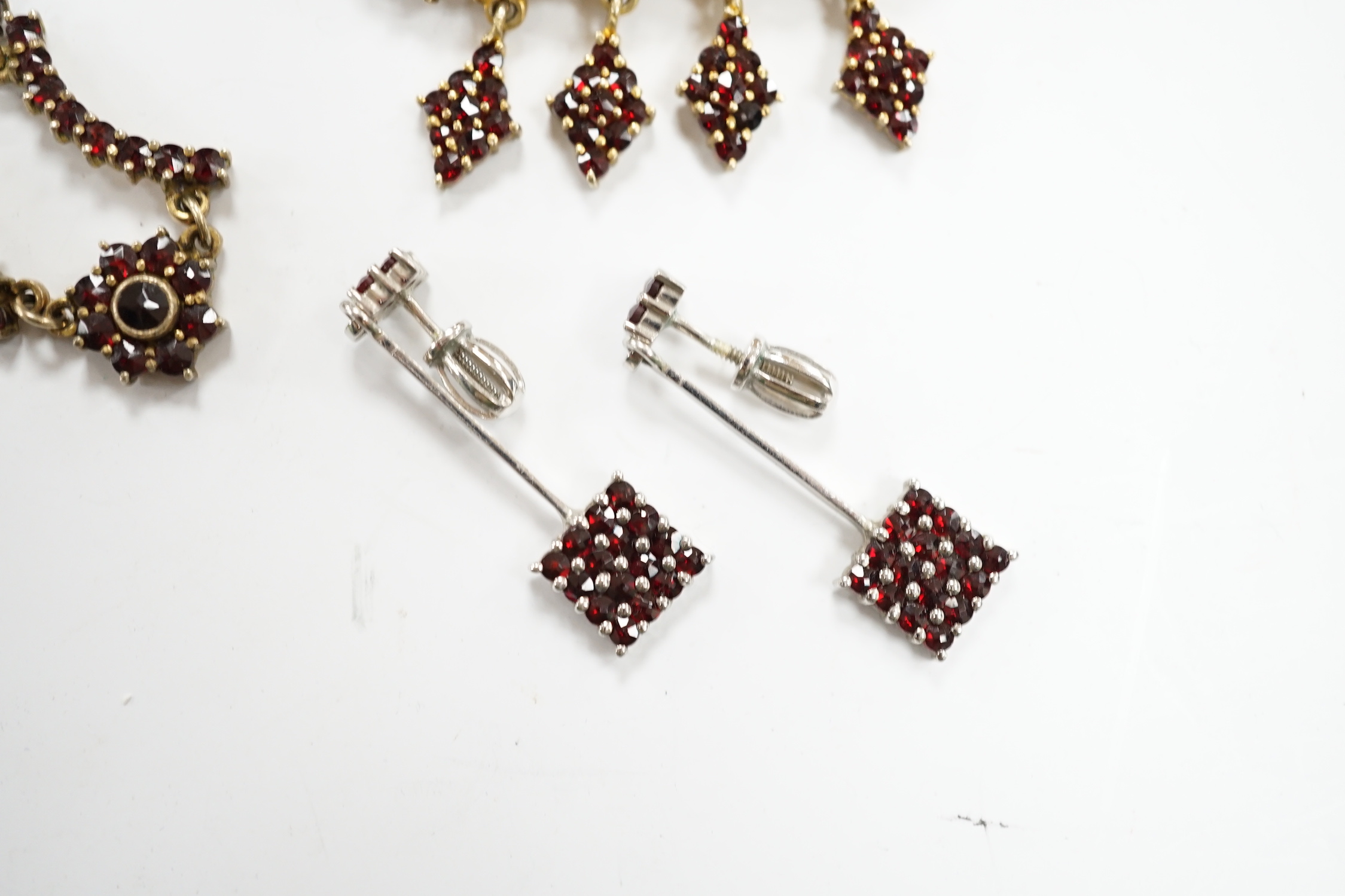 A yellow metal, sapphire and seed pearl cluster set openwork brooch, 23mm, a 9ct and hardstone ring, four items of garnet set jewellery and a pair of jade set ear studs.